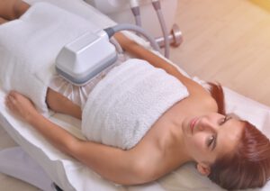 Kryolipolyse-frankfurt Eine Frau liegt während einer Kryliopolyse Behandlung in der Praxis.