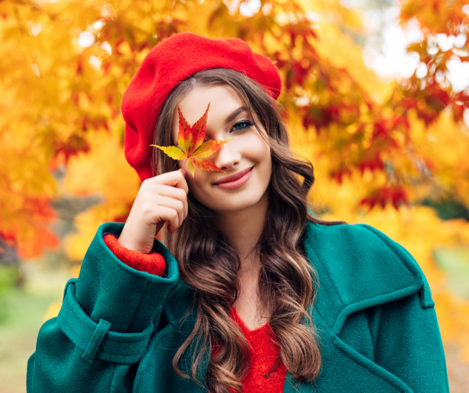 Gesicht einer Frau, herbstliches Portrait. Die Frau hält einen Herbstblatt vor dem Gesicht.